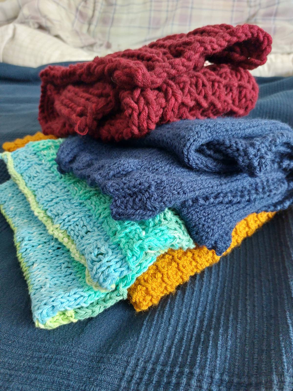 a multi-coloured stack of four folded scarves